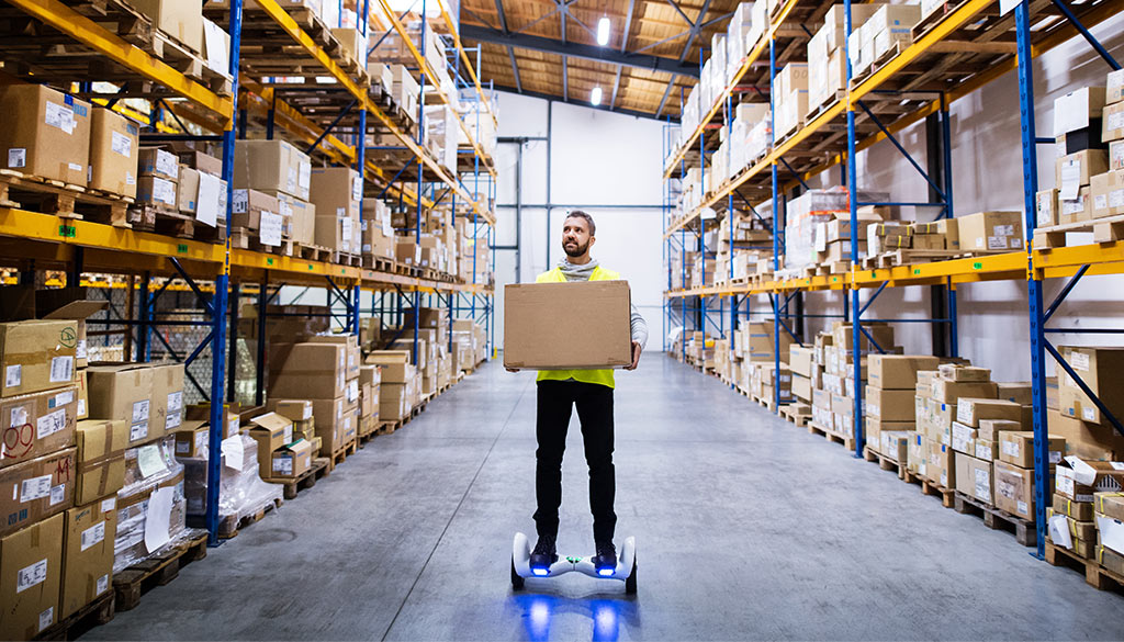 un uomo trasporta oggetti in un magazzino di logistica