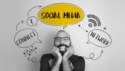 Uomo con la barba sorridente e sullo sfondo la scritta Social Media