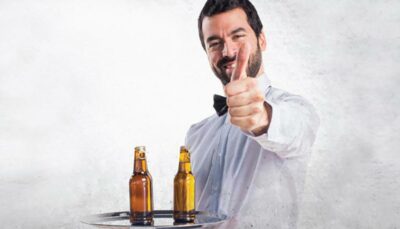 un cameriera che porta 2 birre su un vassaio