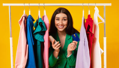 Una giovane donna sorridente sta vendendo i propri vestiti online