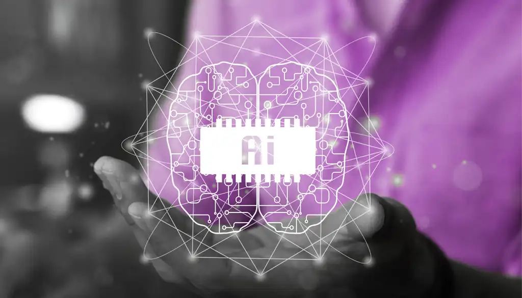 una mano sorregge una illustrazione di un cervello con al centro la scritta AI