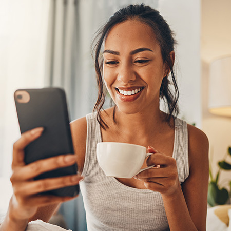 Ragazza sorride mentre guarda una Campagna ADV al telefono