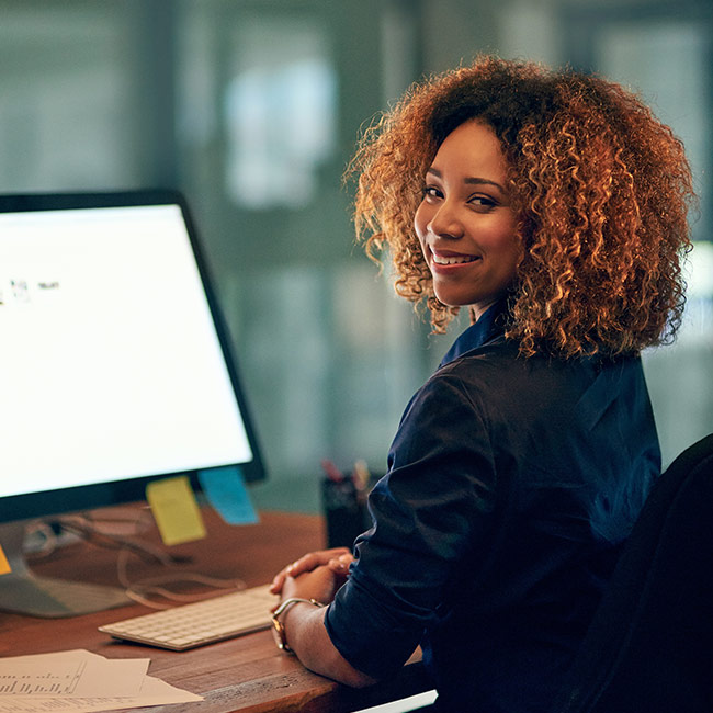 Donna elegante lavora in ufficio al computer come Consulenza SEO per aziende