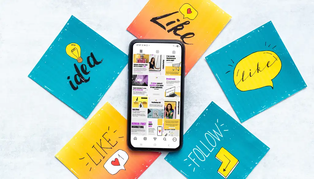 uno smartphone sul quale è visualizzato il canale Instagram di Factory Communication. Intorno allo smartphone 5 cartoline con le scritte: Idea, Like, Follow