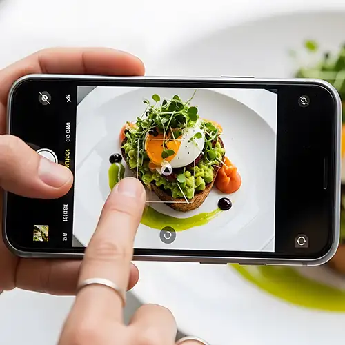 influencer scatta una foto ad un piatto di cibo invitante
