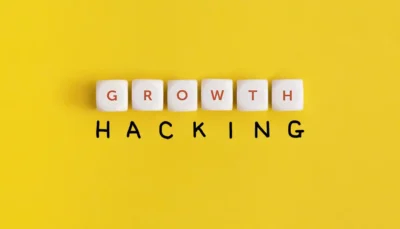 La parola growth è fatta con 6 dadi bianchi. La parola hacking è una scritta a mano di colore nero lo sfondo è giallo